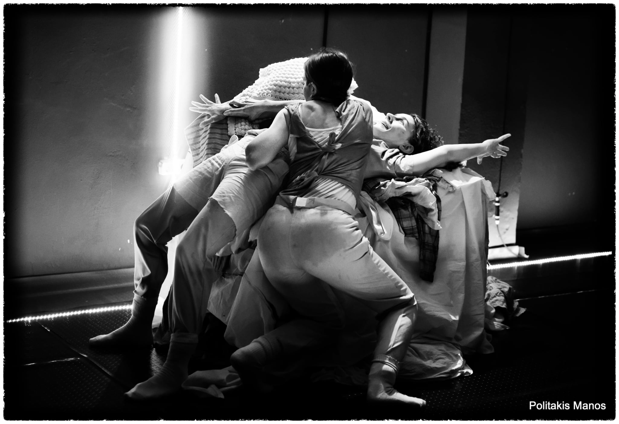 Three performers form a clustered composition, one reaching outward, in Sonderkommando.